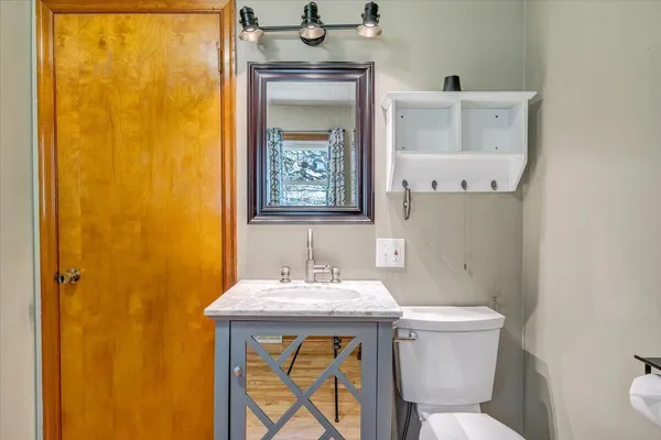a bathroom with a sink mirror vanity and toilet