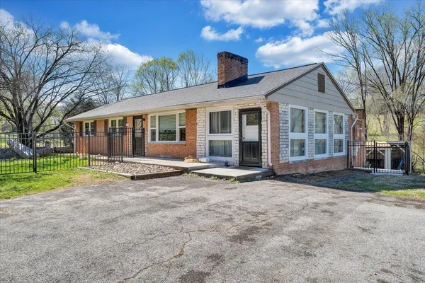 a front view of a house with a yard and trees