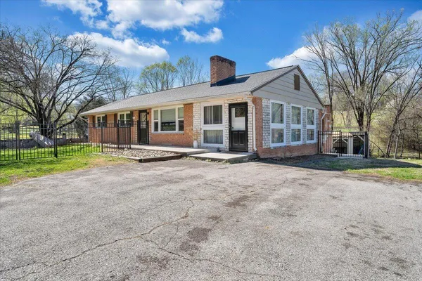 a front view of a house with a yard and trees