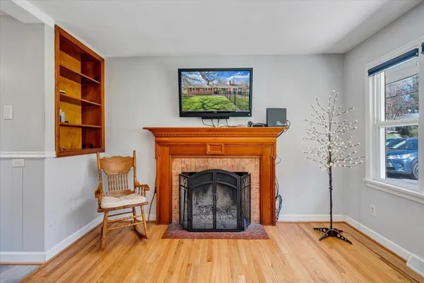a living room with a fireplace windows and a rug