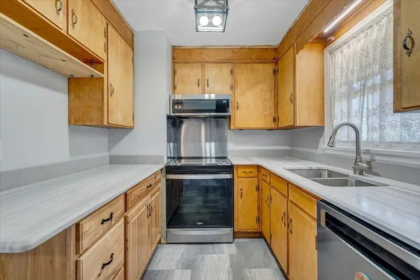 a kitchen with stainless steel appliances granite countertop a sink and a stove