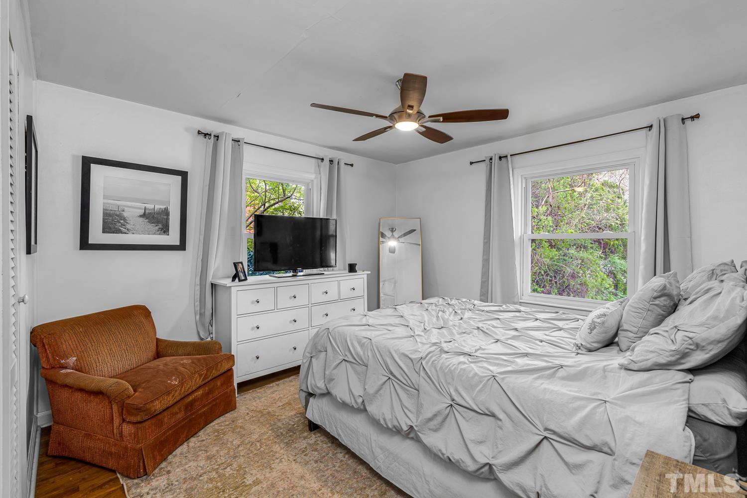 2456 Milburnie Road Raleigh, NC 27610 - Photo 12 of 23 a bedroom with a bed a couch and a flat screen tv