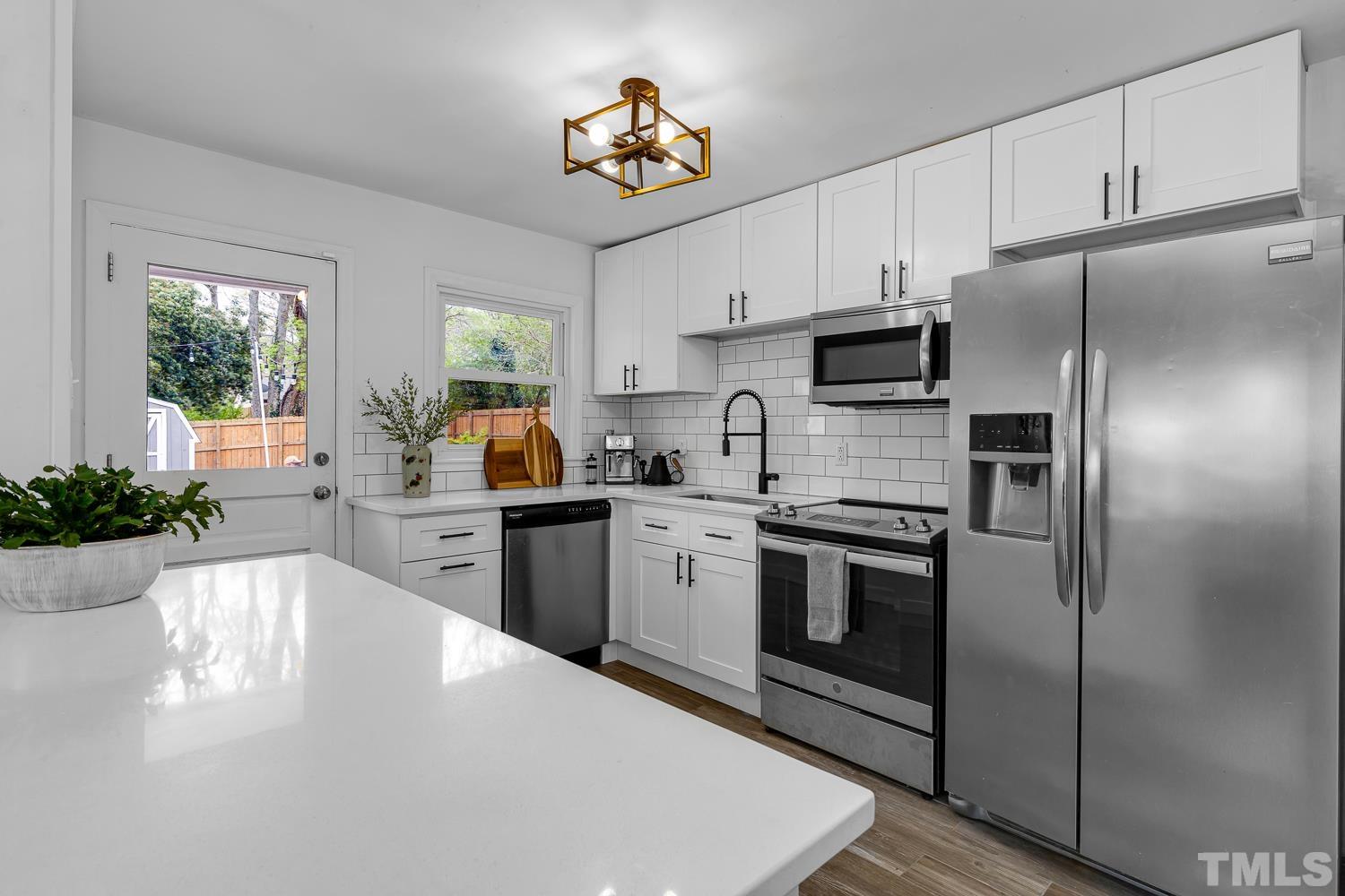 2456 Milburnie Road Raleigh, NC 27610 - Photo 8 of 23 a kitchen with a refrigerator and a stove top oven