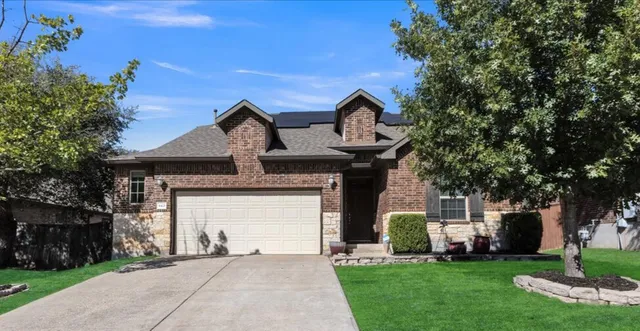 a front view of a house with a garden and plants
