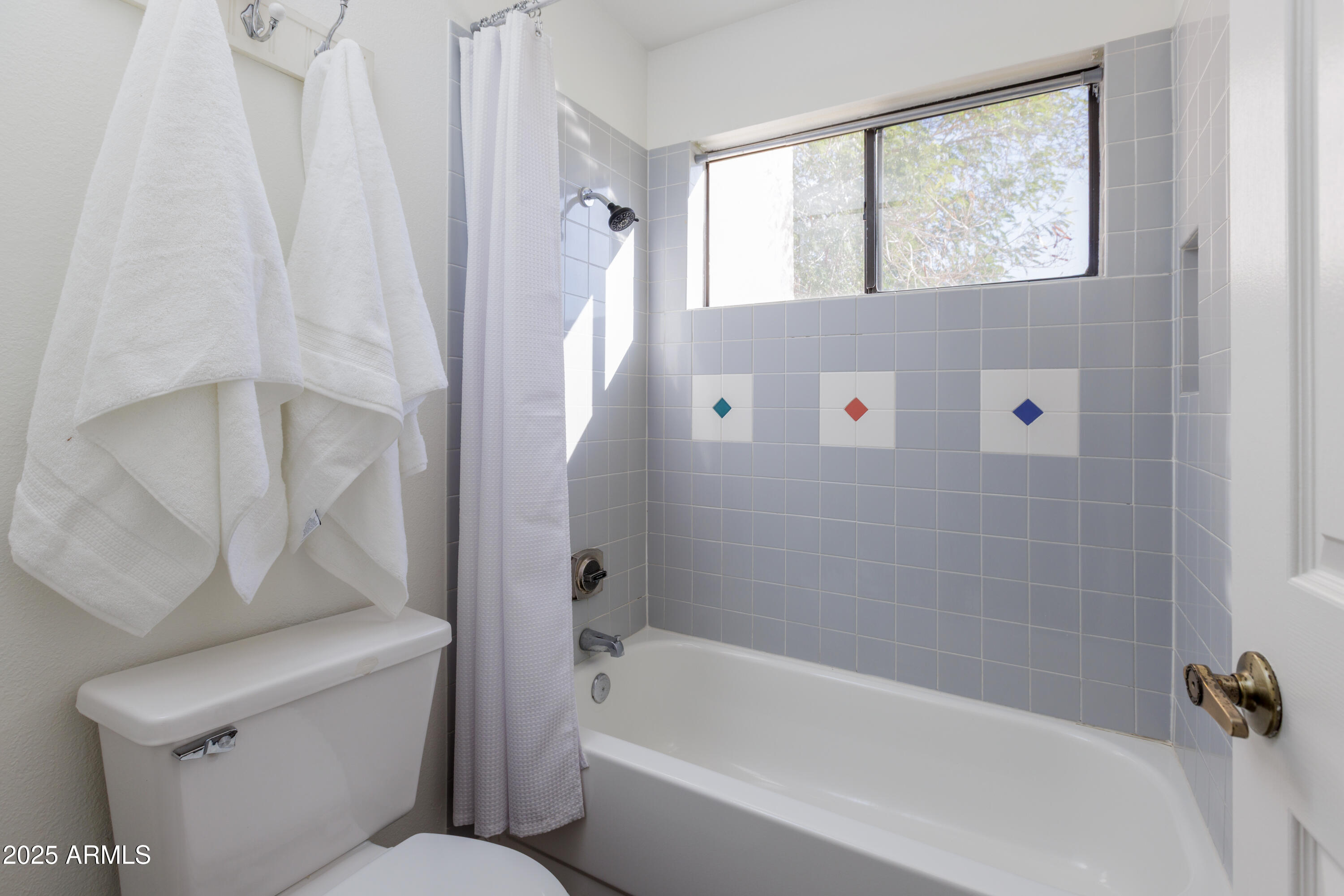 1025 East Highland Avenue, Unit 30 Phoenix, AZ 85014 - Photo 15 of 20 a bathroom with a bathtub and window