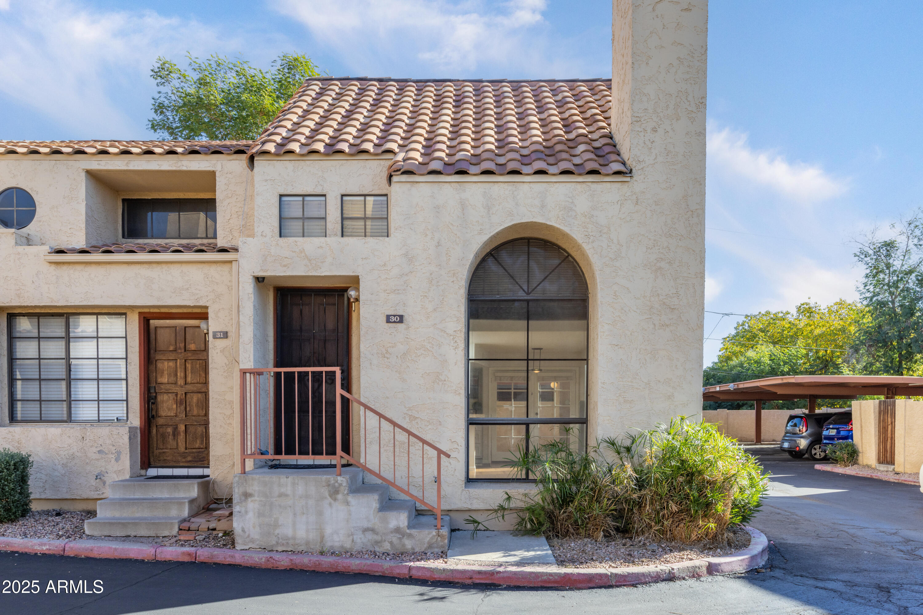 1025 East Highland Avenue, Unit 30 Phoenix, AZ 85014 - Photo 17 of 20 a front view of a house with plants
