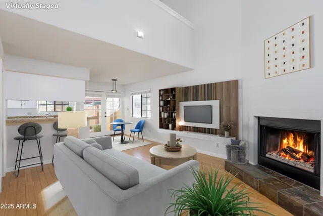 a living room with furniture a flat screen tv and a fireplace