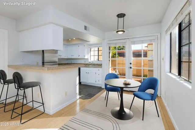a kitchen with stainless steel appliances kitchen island a table and chairs in it
