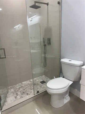 a bathroom with a shower a toilet and a shower
