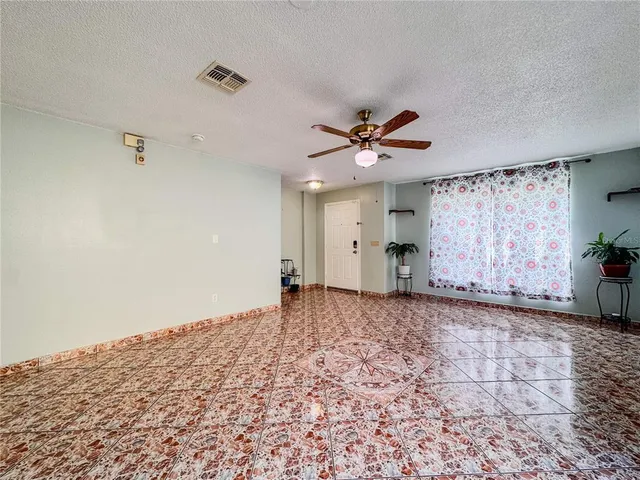 a view of a big room with wooden floor and a chandelier fan