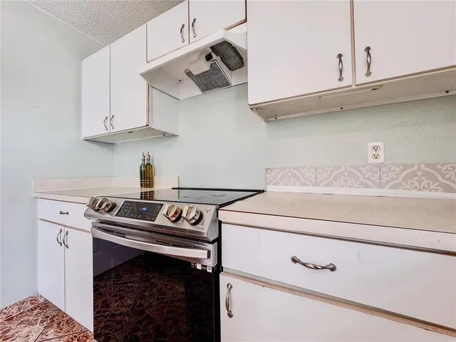 a kitchen with white cabinets and white appliances