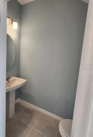 a bathroom with a sink toilet and a mirror