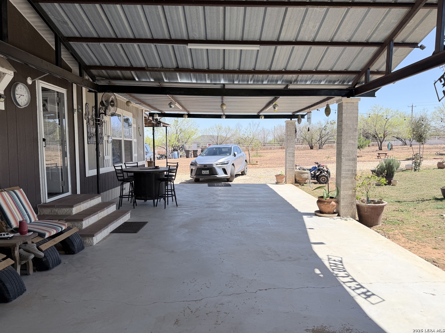 152 County Roads 2667 Devine, TX 78016 - Photo 11 of 51 a view of a patio with table and chairs under an umbrella with a view of the patio