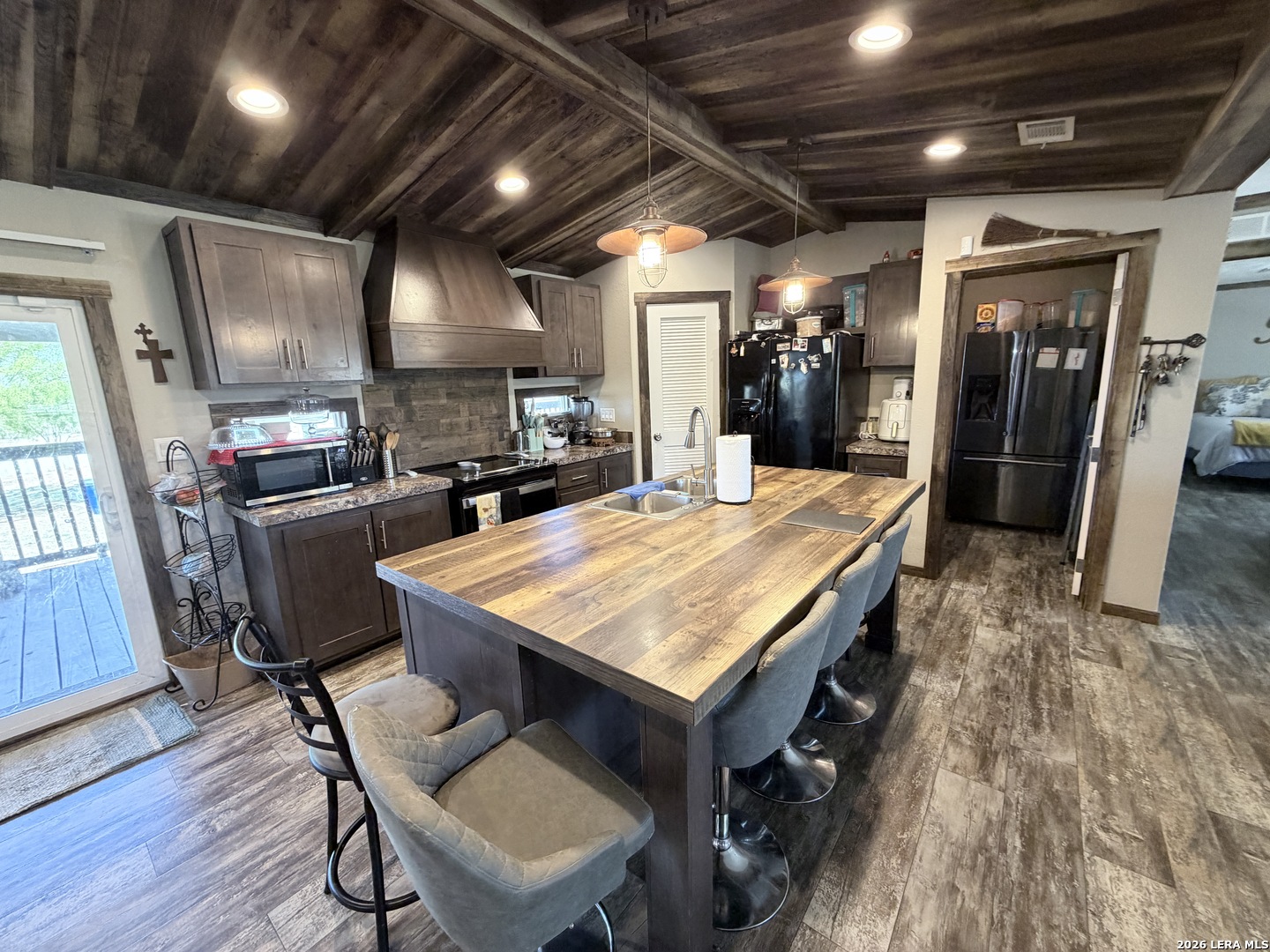 152 County Roads 2667 Devine, TX 78016 - Photo 27 of 51 a room with stainless steel appliances kitchen island granite countertop a table chairs and a refrigerator