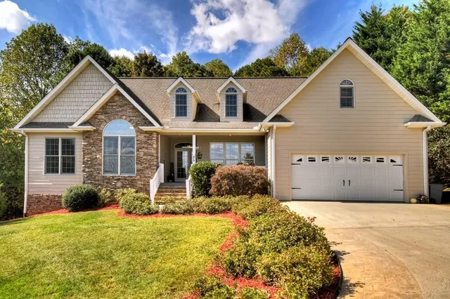 a front view of a house with yard and green space