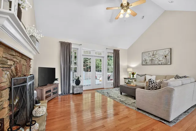 a kitchen with stainless steel appliances granite countertop a stove top oven a sink dishwasher a dining table and chairs with wooden floor