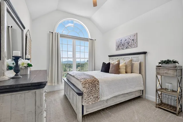 a large bed sitting in a bedroom next to a window