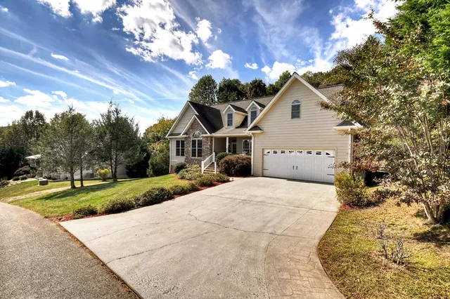 a view of a house with a yard and potted plants