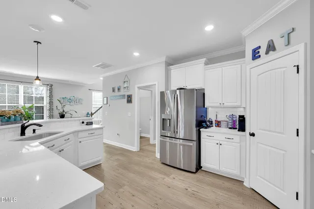a kitchen with a sink cabinets and wooden floor