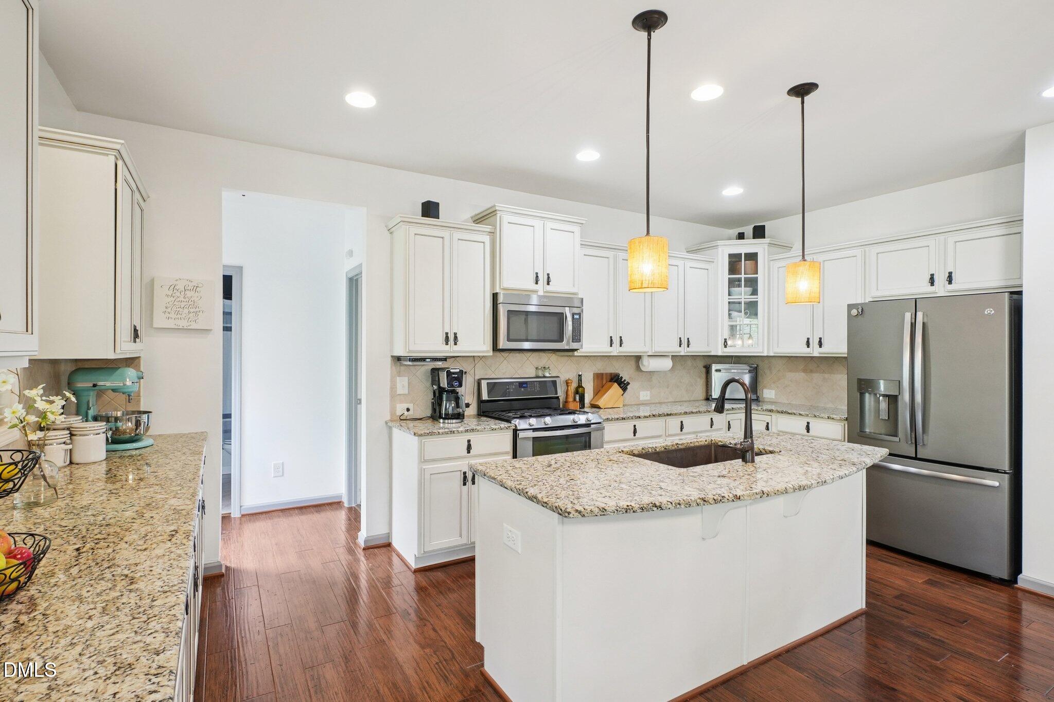 203 Hico Way Durham, NC 27703 - Photo 13 of 62 a kitchen with stainless steel appliances granite countertop a refrigerator a sink a stove and a wooden floors