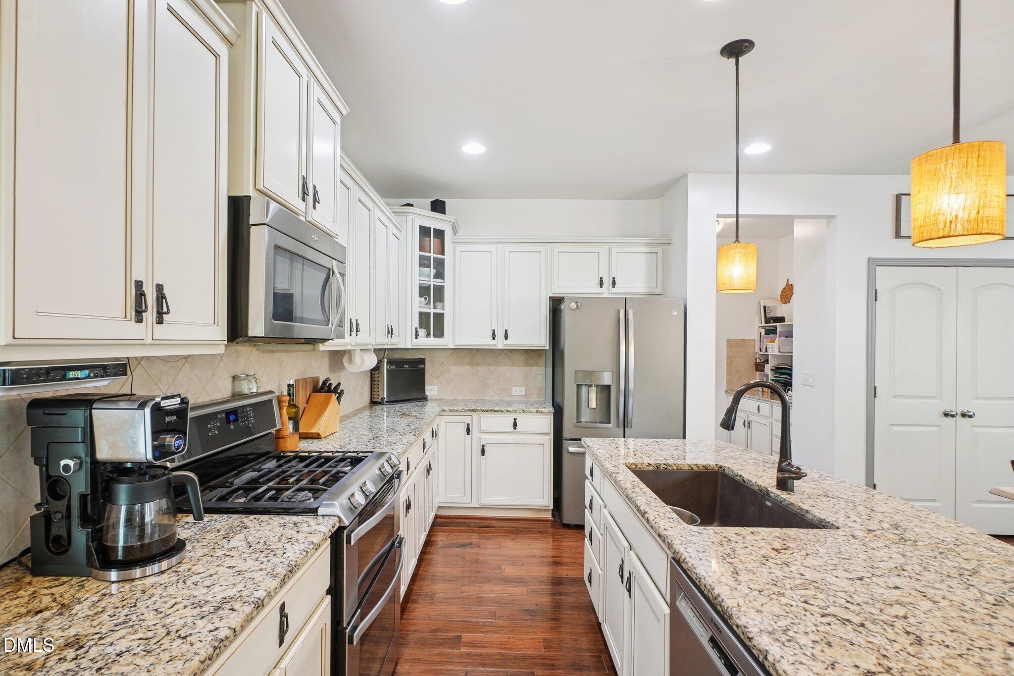 203 Hico Way Durham, NC 27703 - Photo 16 of 62 a kitchen with stainless steel appliances granite countertop a sink stove and refrigerator