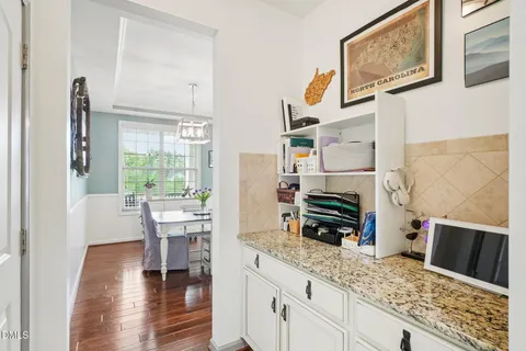 a dining room with wooden floor a chandelier a wooden table and chairs