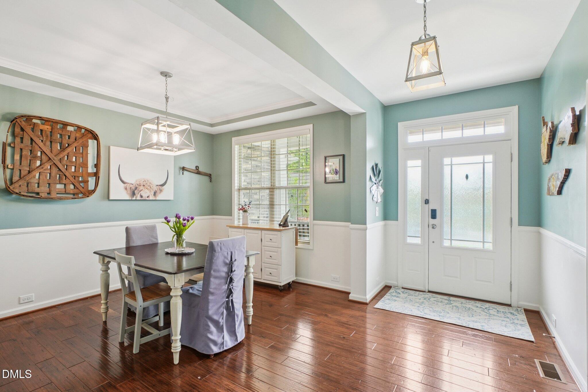 203 Hico Way Durham, NC 27703 - Photo 18 of 62 a dining room with wooden floor a chandelier a wooden table and chairs
