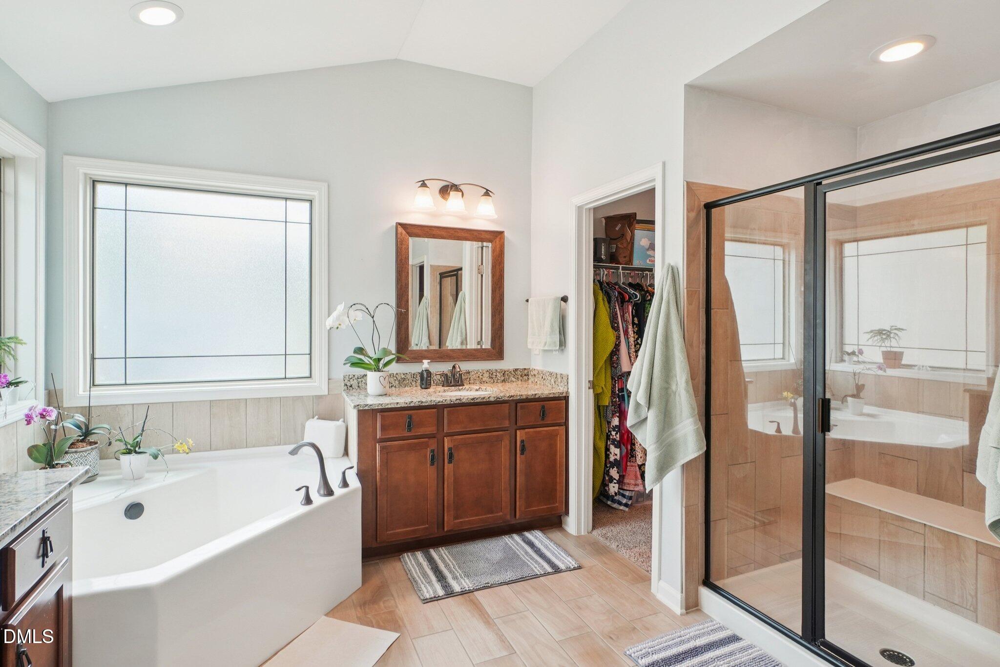 203 Hico Way Durham, NC 27703 - Photo 41 of 62 a bathroom with a tub a double vanity sink and a mirror