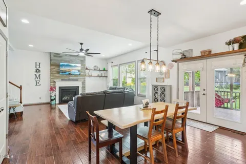 a kitchen with stainless steel appliances granite countertop a stove a refrigerator a kitchen island with white cabinets and wooden floor