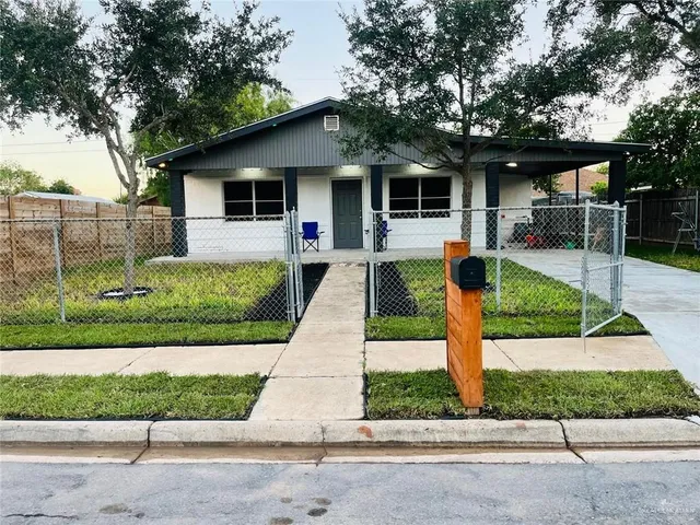 a front view of a house with a yard and potted plants
