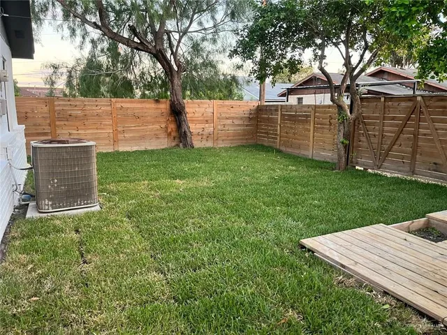 a view of a backyard with wooden fence