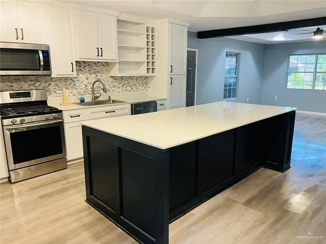 a kitchen with a sink and a stove top oven