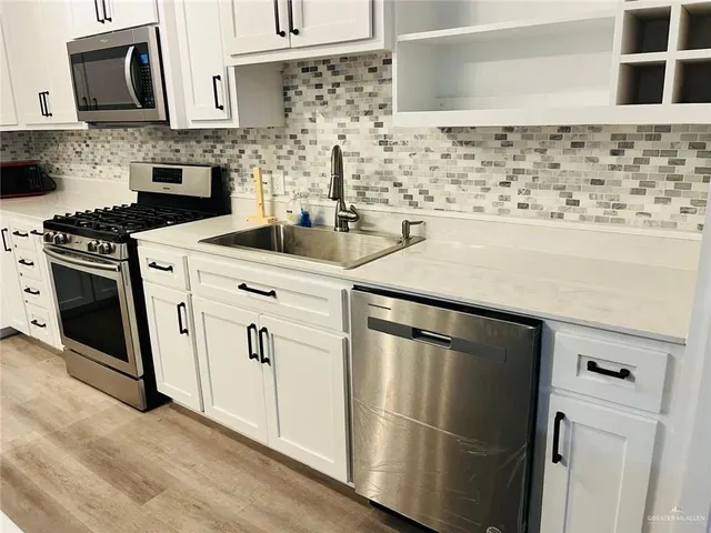 a kitchen with white cabinets and white appliances