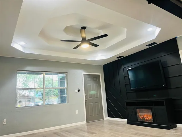 a living room with a fireplace and a ceiling fan