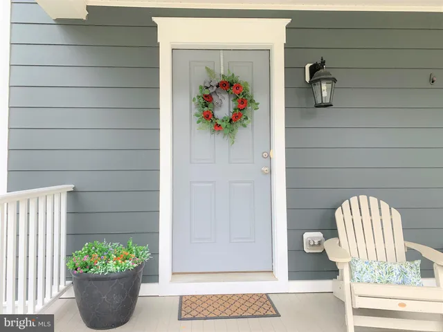 a view of wooden door and chair in a potted plant