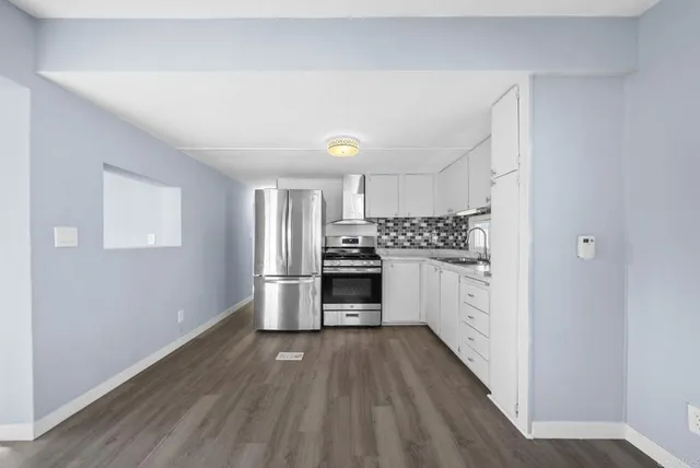 a kitchen with a refrigerator and a stove top oven