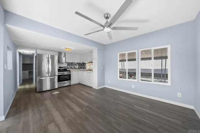 a kitchen with stainless steel appliances wooden floor and a window