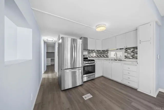 a kitchen with white cabinets and stainless steel appliances