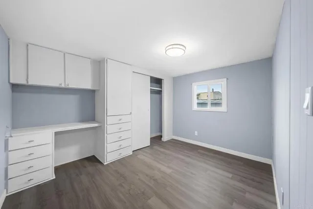 a view of an empty room with cabinet and a window