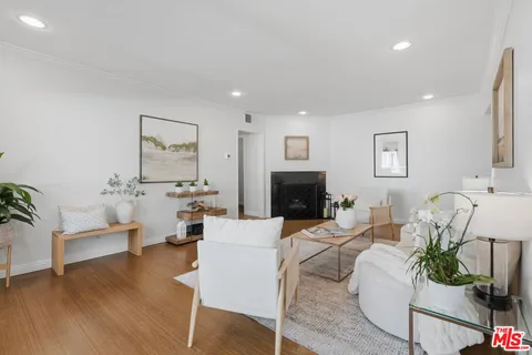 a living room with furniture a fireplace and a potted plant