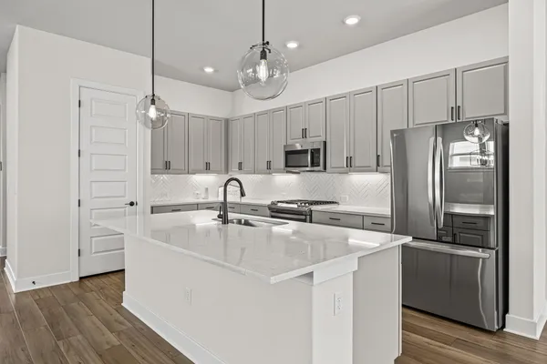 a kitchen with kitchen island a sink stainless steel appliances and cabinets