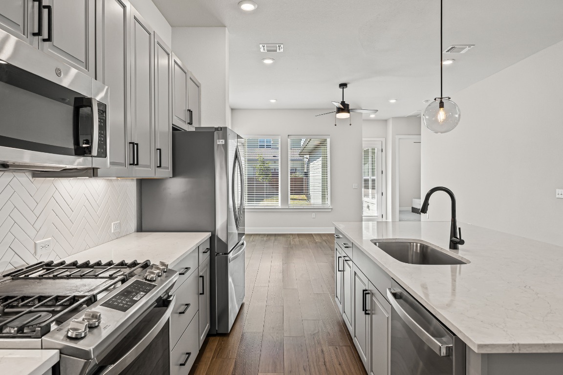 5806 Rangeland Road Austin, TX 78747 - Photo 13 of 33 a kitchen with stainless steel appliances granite countertop a sink stove and refrigerator