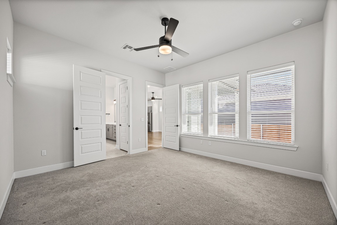 5806 Rangeland Road Austin, TX 78747 - Photo 17 of 33 en empty room with windows and ceiling fan