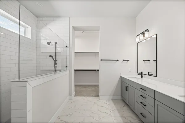 a spacious bathroom with a shower sink and mirror