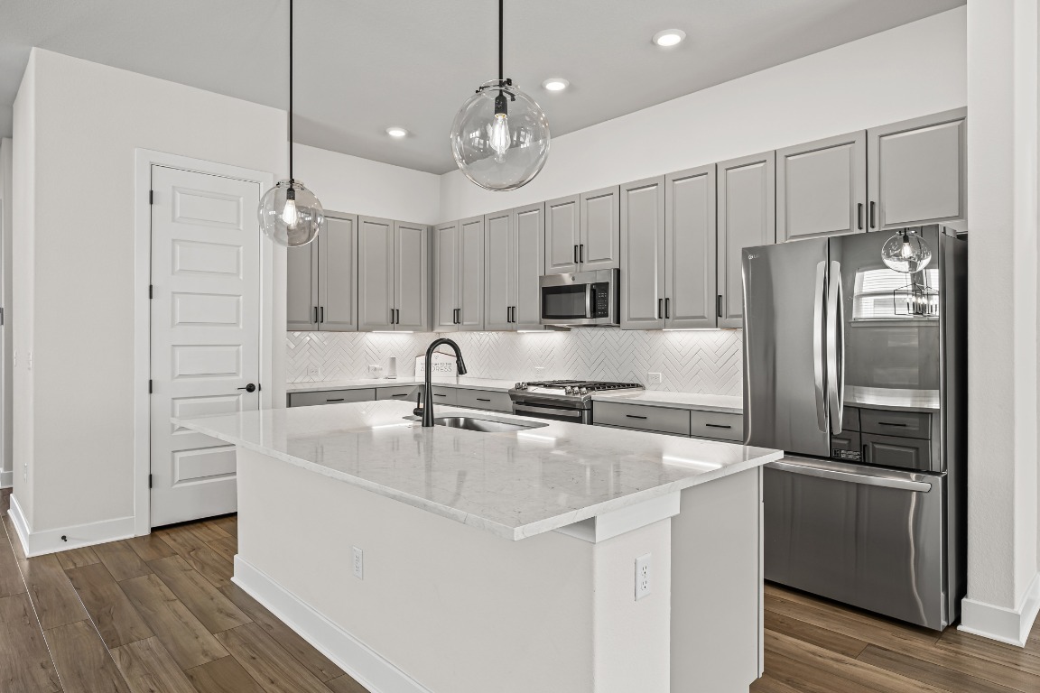 5806 Rangeland Road Austin, TX 78747 - Photo 4 of 33 a kitchen with kitchen island a sink stainless steel appliances and cabinets