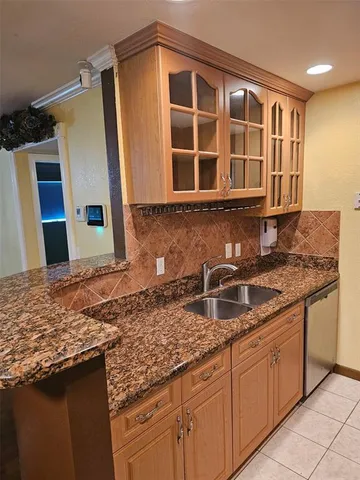 a kitchen with granite countertop a sink and cabinets