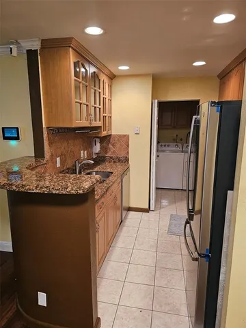 a kitchen with stainless steel appliances granite countertop a refrigerator a sink and wooden cabinets