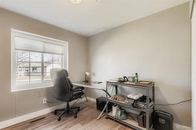 a view of a workspace with furniture and a window