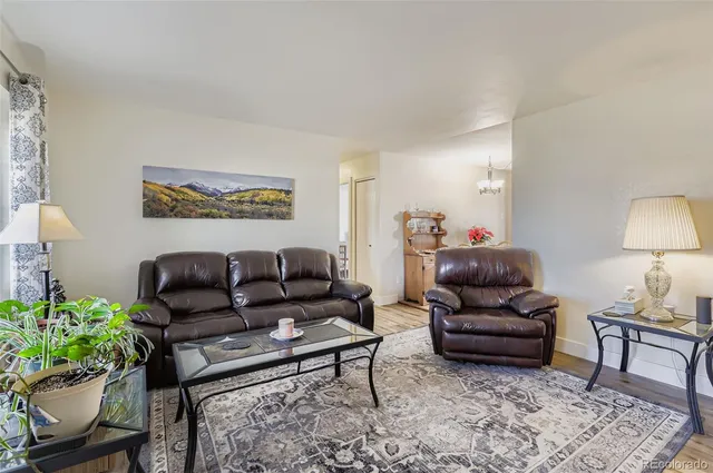 a living room with furniture and a potted plant on coffee table
