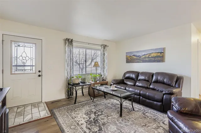 a living room with furniture and wooden floor